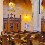 Beautiful church interior featuring wooden pews and ornate wooden carvings.